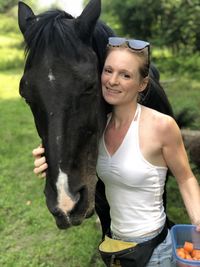 Portrait of woman with horse in park