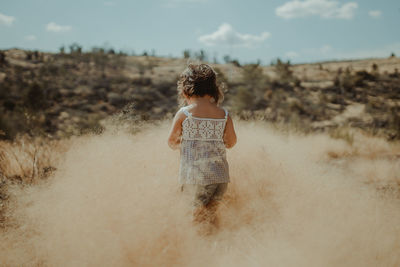 Rear view of girl on field