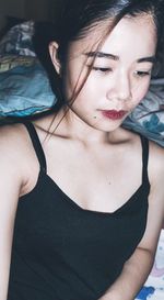 High angle view of thoughtful young woman on bed