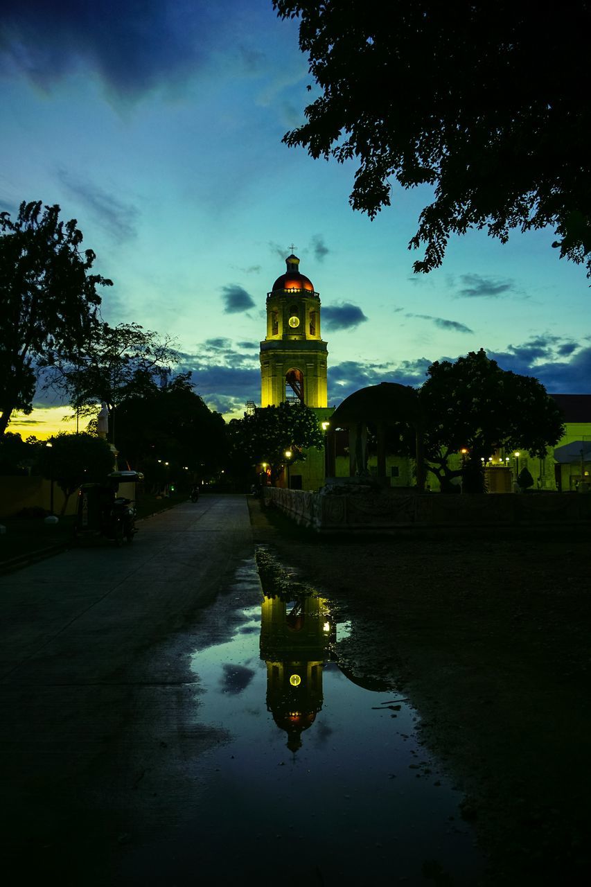 REFLECTION OF CLOCK TOWER IN WATER AT NIGHT