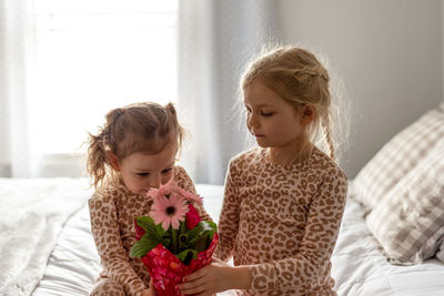 Girl looking away while relaxing on bed at home