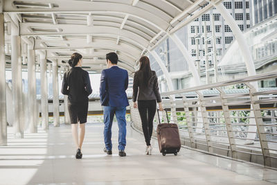 Rear view of people walking on elevated walkway