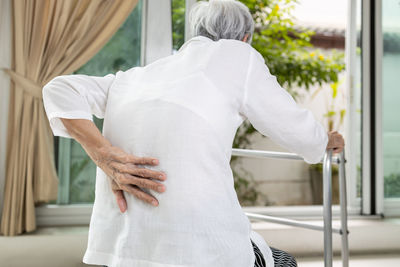 Rear view of senior woman touching back