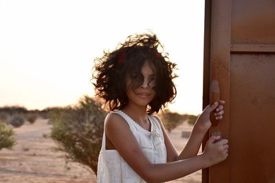 Portrait of smiling young woman standing outdoors