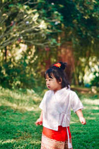 Portrait of young woman standing on field