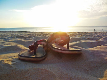 Close-up of man on beach against sky during sunset