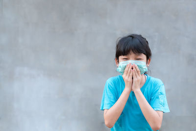 Full length portrait of boy standing against wall