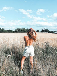 Full length of woman standing on field against sky