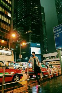 Full length of man standing in illuminated city at night