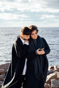 Young couple standing on sea shore