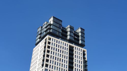 Low angle view of modern building against clear blue sky