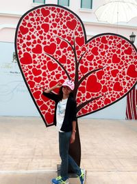 Portrait of woman standing against heart shape tree