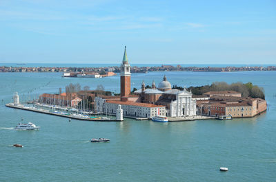 Boats in sea against buildings in city