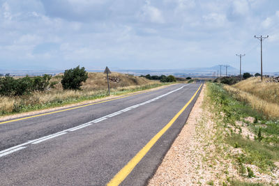 Road by trees against sky