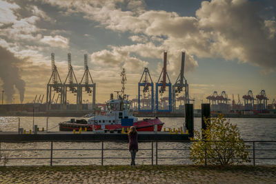 Woman standing at harbor during sunset