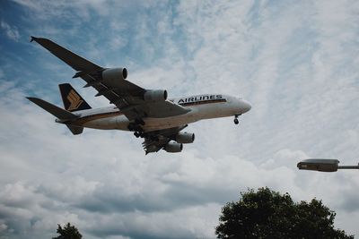 Low angle view of airplane flying against sky