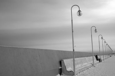 Street light by sea against sky