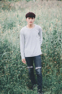 Portrait of young man standing against plants