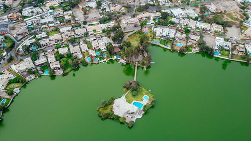 High angle view of boats moored in lake amidst buildings