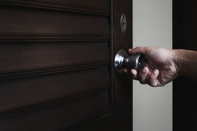 Midsection of man holding door