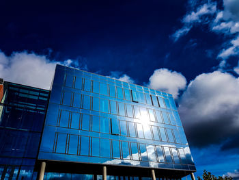 Low angle view of modern building against blue sky