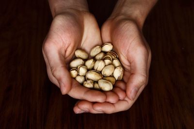 Cropped hands holding pistachio