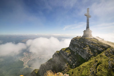 View of cross on mountain against sky