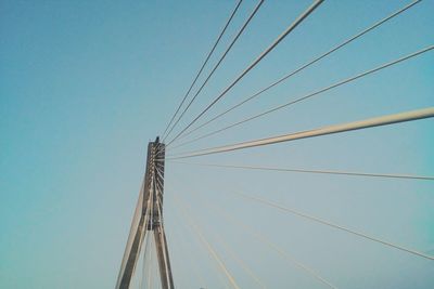 Low angle view of suspension bridge against clear blue sky