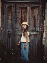 Portrait of girl standing against door