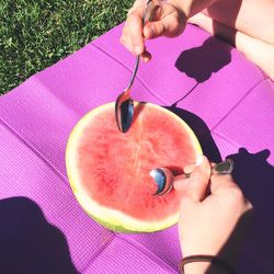 Cropped image of hands scooping watermelon