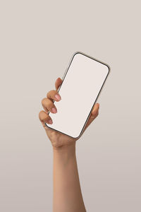 Close-up of hand holding smart phone over white background