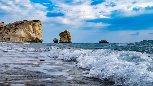 Rocks on sea shore against sky