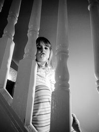 Low angle portrait of boy standing against curtain