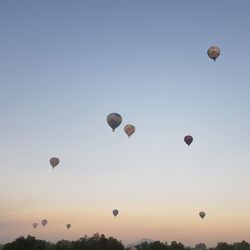 Low angle view of hot air balloons against sky during sunrise