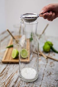 Close-up of hand holding drink on table