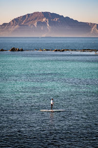 Scenic view of sea by mountain against sky. paddlesurf strait of gibraltar. 
