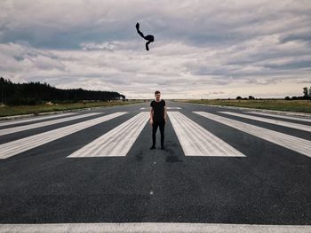 Man standing on road against sky