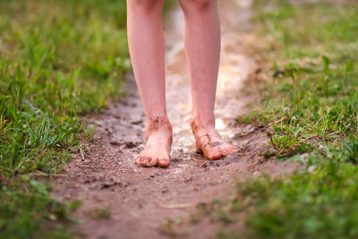 Low section of standing in puddle by grass outdoors