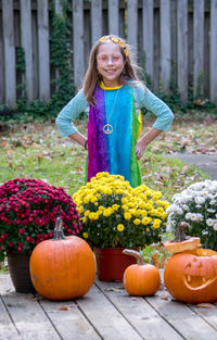 A cute little girl poses in a colorful hippie costume for a halloween trick or treat