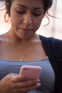 Portrait of young woman using mobile phone