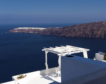 Scenic view of sea and mountains against blue sky