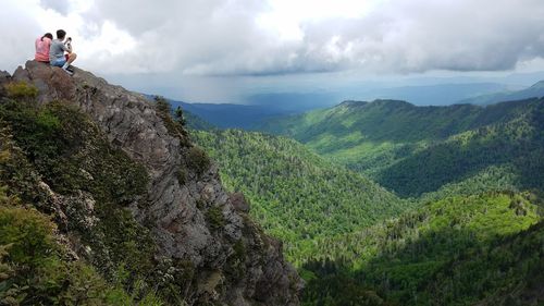 Panoramic view of people on mountain against sky