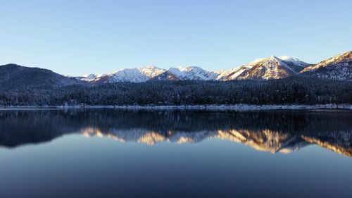 Mountains reflecting on calm lake during winter