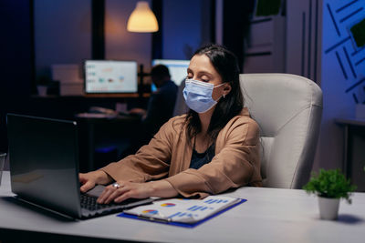 Businesswoman wearing mask working in office