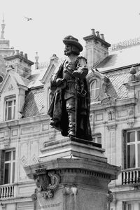 Low angle view of statue against building in city