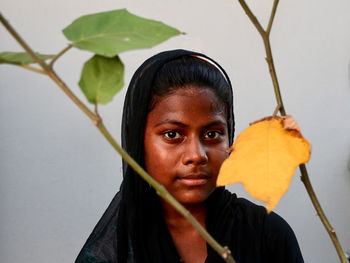 Portrait of young woman holding leaves outdoors