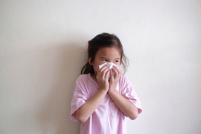 Portrait of a girl standing against wall