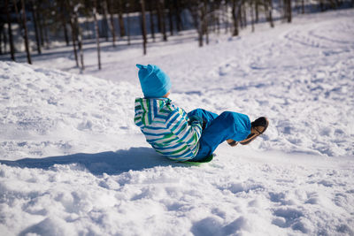 Rear view of boy on snow covered land