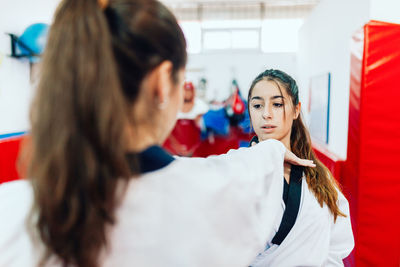 Instructor teaching martial arts to young woman