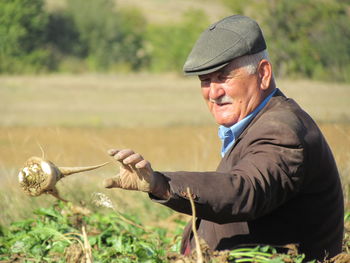 Man holding radish while working in farm